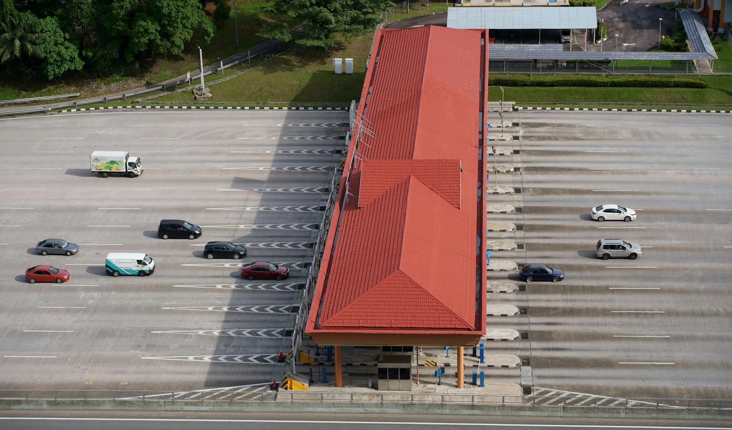 A side shot of a highway with cars driving into tolls